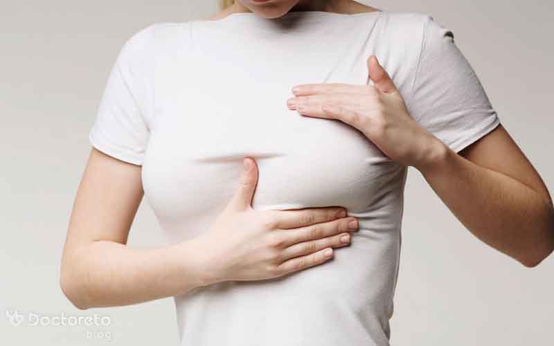 وجود توده‌ سفت در سینه از نشانه‌های سرطان سینه در دختران است. 